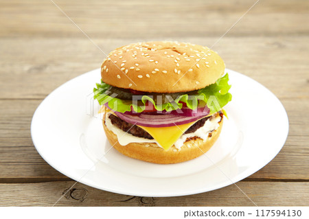 Burger in a white plate on grey wooden table 117594130