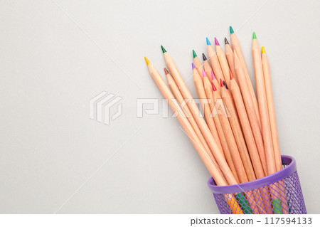 Colored pencils in a pencil case on grey background. 117594133
