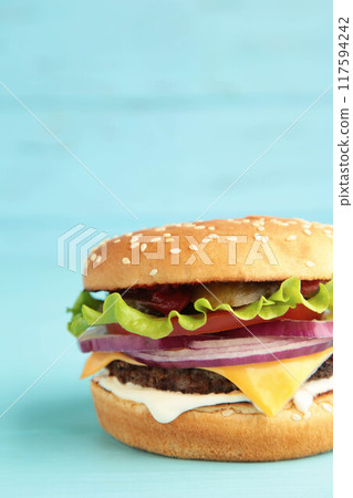 Fresh tasty burger on blue wooden background Fresh tasty burger on blue wooden background 117594242