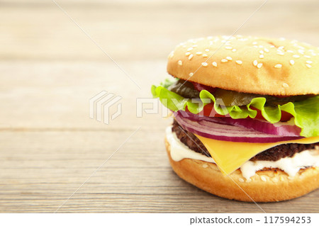 Homemade hamburger with vegetables on grey background. Homemade hamburger with vegetables on grey background. 117594253