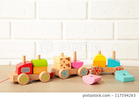 Stacking train toddler toy for little children on light background with shadow reflection. 117594263