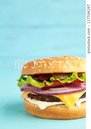 Fresh tasty burger on blue wooden background Fresh tasty burger on blue wooden background 117594267