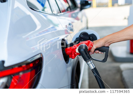 A man who refuels at a gas station 117594365