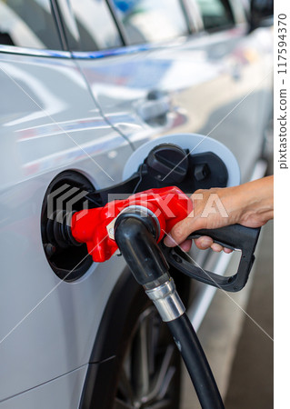 A man who refuels at a gas station 117594370