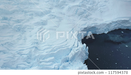 Aerial panorama glacier snow mass wall in Antarctica towering cold polar ocean. Massive snow covered iceberg floats cold water. Ecology, melting ice, climate change, global warming. Explore Arctic Aerial panorama glacier snow mass wall in Antarctica towering cold polar ocean. Massive snow covered iceberg floats cold water. Ecology, melting ice, climate change, global warming. Explore Arctic 117594378