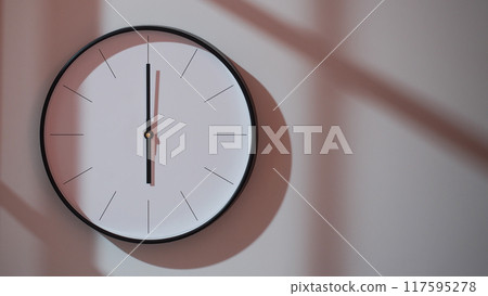 Elegant Black Clock Showing 18.00/06.00 with Shadows on Minimalist Wall - Ideal for Time Management and Interior Design Promotions Elegant Black Clock Showing 18.00/06.00 with Shadows on Minimalist Wall - Ideal for Time Management and Interior Design Promotions 117595278