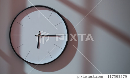 Elegant Black Clock Showing 18.15/06.15 with Shadows on Minimalist Wall - Ideal for Time Management and Interior Design Promotions Elegant Black Clock Showing 18.15/06.15 with Shadows on Minimalist Wall - Ideal for Time Management and Interior Design Promotions 117595279