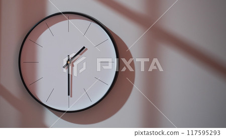 Elegant Black Clock Showing 13.30/01.30 with Shadows on Minimalist Wall - Ideal for Time Management and Interior Design Promotions Elegant Black Clock Showing 13.30/01.30 with Shadows on Minimalist Wall - Ideal for Time Management and Interior Design Promotions 117595293
