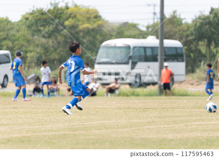 Elementary school boy playing soccer match 117595463