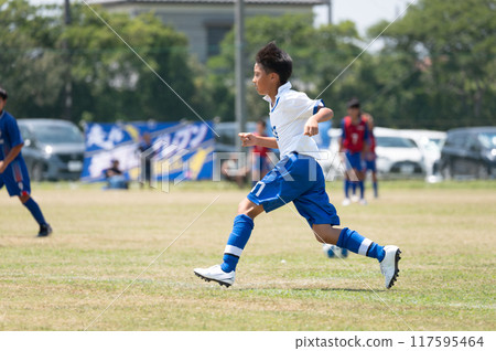 Elementary school boy playing soccer match 117595464