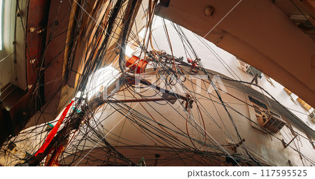 Electric cables chaos, Indian street wires. Messy electrical cables, Uncovered optical fiber technology open air outdoors in asian cities. utility pole supporting a mass of wiring, some of it 117595525