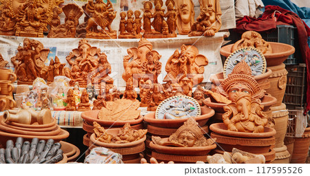 Statues Of Buddha Head And Ganesha On Market. Popular Souvenirs From India. selling pots, vases and other Oriental Ceramic Traditional Handmade Clay dishware Jugs On The Main Bazar market place 117595526