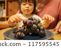Girl eating grapes 117595545