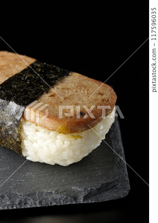 Spam musubi on a slate plate photographed against a black background Spam musubi on a slate plate photographed against a black background 117596035