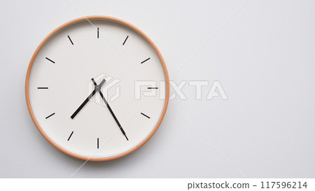 Minimalist wooden Wall Clock on White Wooden Surface with Space for Text.  Time Set at 19.25/07.25 117596214