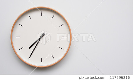 Minimalist wooden Wall Clock on White Wooden Surface with Space for Text.  Time Set at 19.35/07.35 117596216