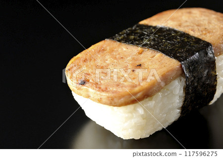 Spam musubi photographed against a black background Spam musubi photographed against a black background 117596275