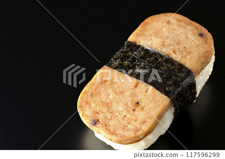 Spam musubi photographed against a black background Spam musubi photographed against a black background 117596299
