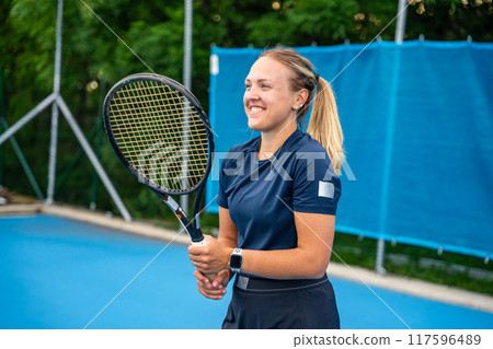 Professional female tennis player playing in tennis with racket and ball on outside court 117596489