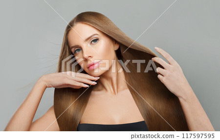Charming female model brunette with long hair and natural make-up posing isolated  117597595