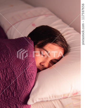 Child Sleeping in Bed with Soft Light 117597656
