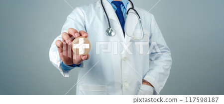 Doctor showing circle wood plank and plus sign represents medical health care and doctor staff service concept, Insurance in health care and medicine concept. Doctor showing circle wood plank and plus sign represents medical health care and doctor staff service concept, Insurance in health care and medicine concept. 117598187
