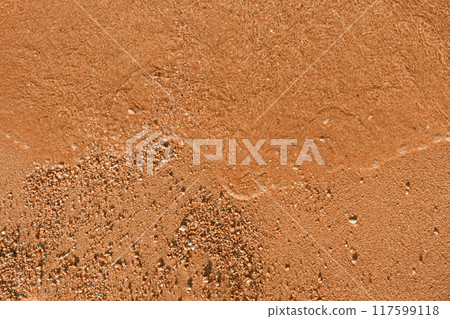 Close-up of the texture of sand and water waves on a beach. 117599118