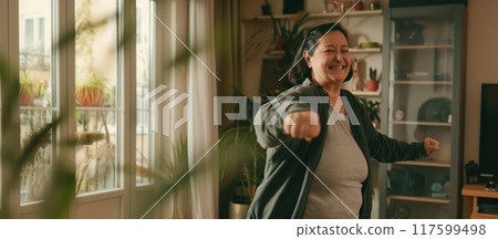 positive older woman working out and dancing at home in the room positive older woman working out and dancing at home in the room 117599498