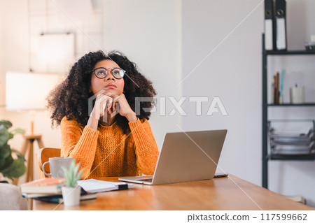 Tired African American Woman Adjusting Glasses at Laptop at Home. 117599662