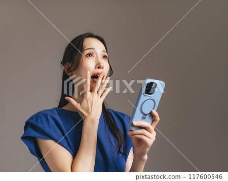 Surprised woman with a smartphone Surprised woman with a smartphone 117600546