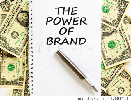 The power of brand symbol. Concept words The power of brand on beautiful white note. Black pen. Beautiful dollar bills background. Dollar bills. Business the power of brand concept. Copy space. 117601423