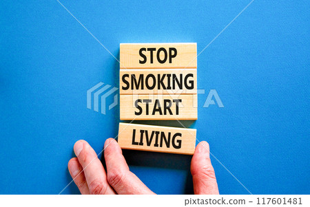 Stop smoking start living symbol. Concept words Stop smoking start living on cubes. Beautiful blue background. Doctor hand. Medical healthy lifestyle stop smoking start living concept. Copy space. 117601481