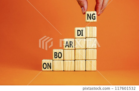 Onboarding success symbol. Concept word Onboarding on wooden cubes. Beautiful orange background. Businessman hand. Business onboarding success concept. Copy space. 117601532