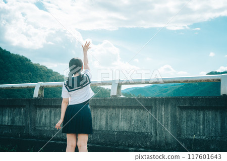 一個穿著水手服的女孩在橋上伸向藍天的後視圖 一個穿著水手服的女孩在橋上伸向藍天的後視圖 117601643