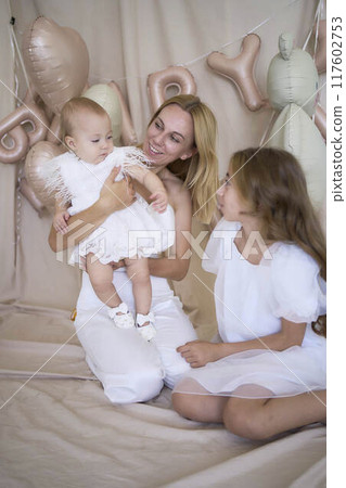 photo session on the first birthday of a baby girl with her mother and teenage sister, in pastel colors, minimalism 117602753