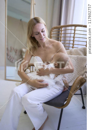 mother breastfeeding her baby, minimalist stylish interior, pastel colors 117602757