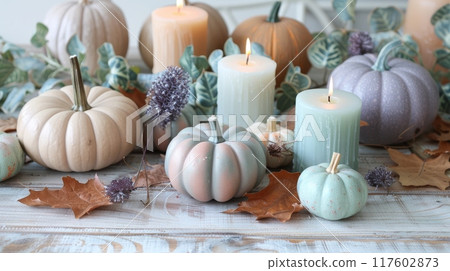 Thanksgiving decorations, pastel pumpkins, mint green leaves, and lavender candles on wooden table 117602873