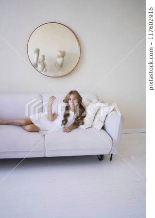 beautiful pre-teen girl in white clothes in a stylish minimalist interior beautiful pre-teen girl in white clothes in a stylish minimalist interior 117602916
