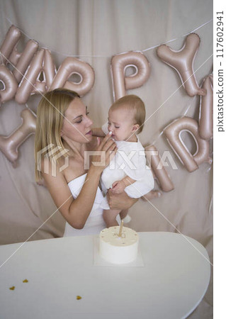 baby girl tries her first birthday cake with mom and pre-teen sister baby girl tries her first birthday cake with mom and pre-teen sister 117602941