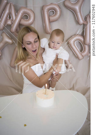 baby girl tries her first birthday cake with mom and pre-teen sister baby girl tries her first birthday cake with mom and pre-teen sister 117602948