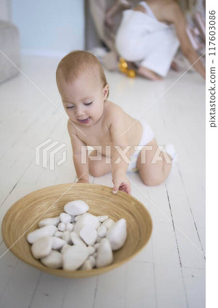 photo session on the first birthday of a baby girl, baby play with decorative rocks 117603086