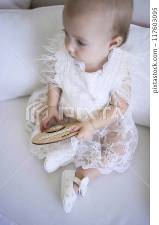 photo session on the first birthday of a baby girl, baby hold decor with writed "12 months" in ukrainian language 117603095