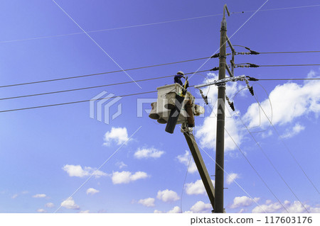 A person working at height with the sky in the background 117603176