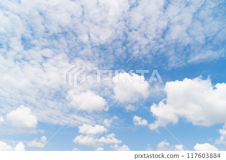 Scattered cumulus clouds against a blue sky, sunlight filtering through. Climate changes concept. Scattered cumulus clouds against a blue sky, sunlight filtering through. Climate changes concept. 117603884
