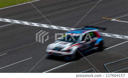 Motion blur race car racing on speed track, Car race on the international circuit race track crossing start and finish line, Race car crossing start and finish line, Target business achieve victory. Motion blur race car racing on speed track, Car race on the international circuit race track crossing start and finish line, Race car crossing start and finish line, Target business achieve victory. 117604157