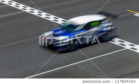 Motion blur race car racing on speed track, Car race on the international circuit race track crossing start and finish line, Race car crossing start and finish line, Target business achieve victory. 117604163