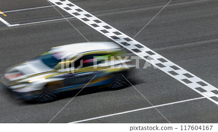 Motion blur race car racing on speed track, Car race on the international circuit race track crossing start and finish line, Race car crossing start and finish line, Target business achieve victory. 117604167