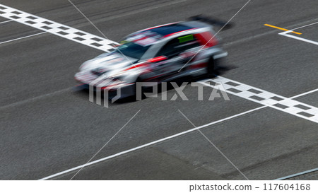 Motion blur race car racing on speed track, Car race on the international circuit race track crossing start and finish line, Race car crossing start and finish line, Target business achieve victory. 117604168