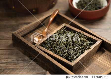 Green tea in wooden box and barrel on wooden board 117605082