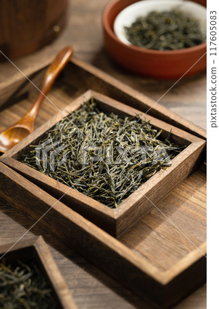 Green tea in wooden box and barrel on wooden board 117605083
